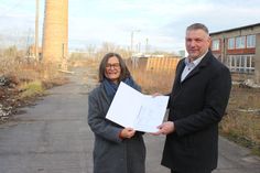 Staatssekretärin Barbara Meyer überreicht dem Bürgermeister von Ottendorf-Okrilla, Rico Pfeiffer, den Fördermittelbescheid.