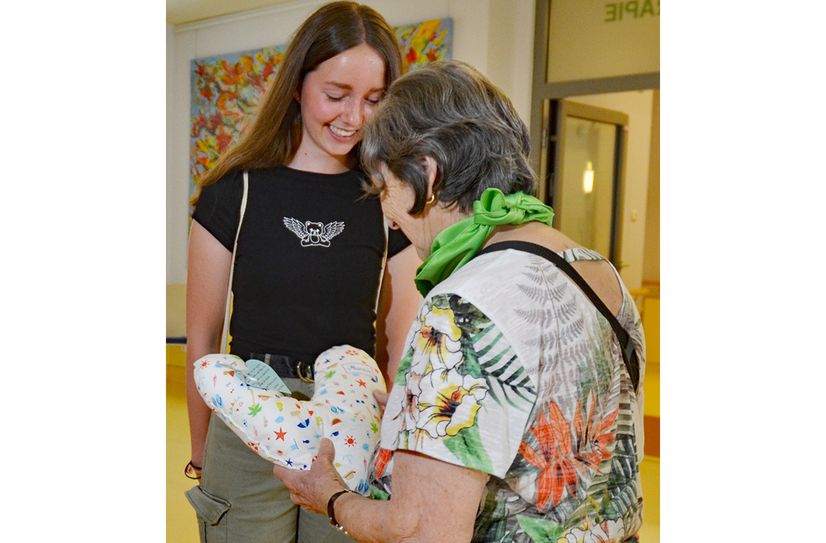 Maria übergibt ihr Herzkissen an eine Patientin.