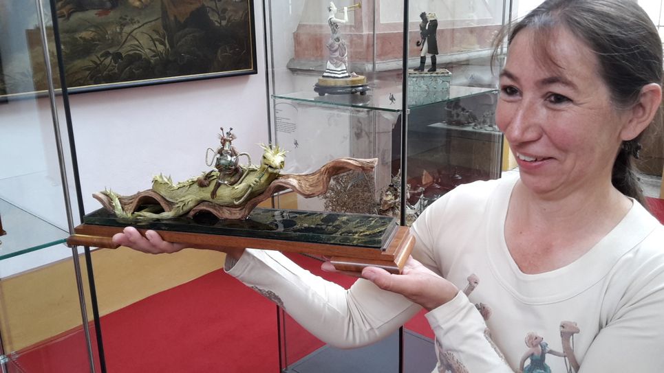 Barbara Lenz mit einer ihrer Federfiguren: Gecko mit Wasserpfeife. Foto: © Schlösserland Sachsen / Schloss Moritzburg & Fasanenschlösschen
