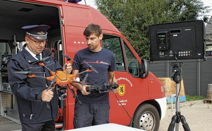 Einsatzberatung vor dem Start der Drohne zwischen Kreisbrandmeister Ingo Nestler (I.) und Drohnen-Pilot Marcus Mambk. Ingo Nestler kontrolliert die Bilder der Drohne an einem Monitor. Foto: Thöns