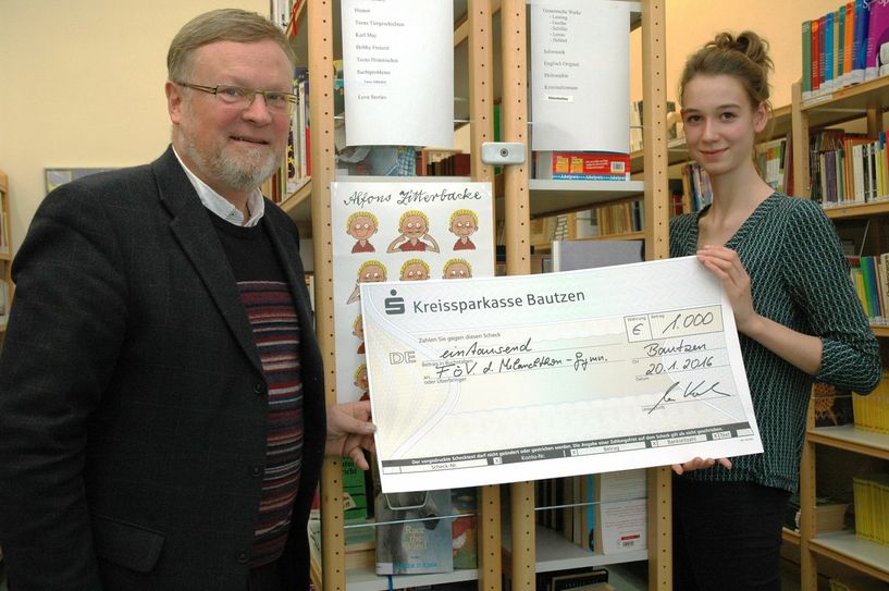 Die stellvertretende Schülersprecherin Lilly Roitsch nahm voller Vorfreude von Stiftungsratschef Uwe Koch den Scheck für die Bibliothek des Melanchthon-Gymnasiums entgegen. Foto: Hache