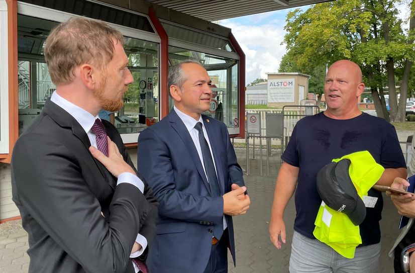 Ministerpräsident Michael Kretschmer, Oberbürgermeister Octavian Ursu und der Betriebsratsvorsitzende René Straube vor dem Werk in Görlitz.