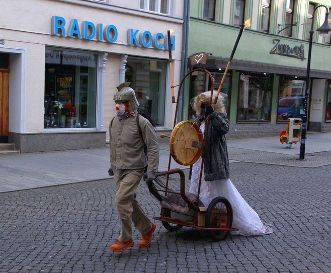 Eine geheimnisvolle Performance wurde pünktlich 11 Uhr in der Riesaer Innenstadt aufgeführt: Einer wird vor einen Karren gespannt und soll im Trommelklang des anderen (im Brautkleid und mit dem Kopf in einem Käfig) alles über sich ergehen lassen... Foto: Farrar