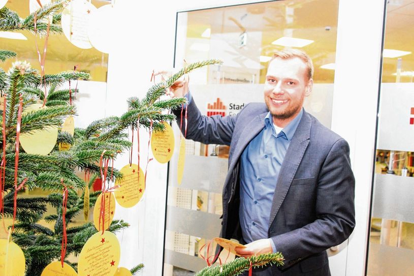 Der Forster Bürgermeister Philipp Wesemann ließ es sich nicht nehmen, die ersten Kinderwünsche am Baum vor der Stadtbibliothek im Rathaus anzuhängen. Insgesamt 140 Wünsche von Kindern sind an drei Bäumen in der Stadt platziert. Fotos: jho