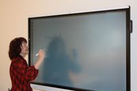 Klassenleiterin Kerstin Hänsel bereitet an einer interaktiven Tafel einen Willkommensgruß für ihre Zweitklässler vor.