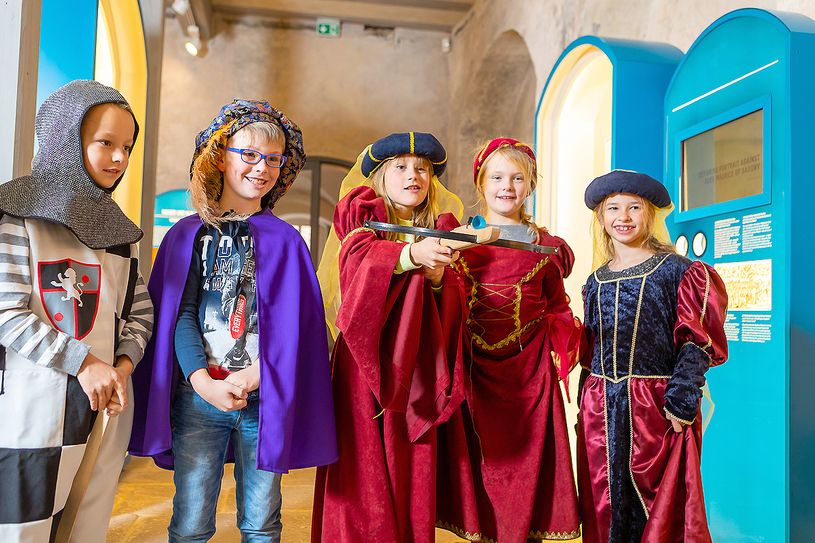 Unterwegs im historischen Gewand: Kinder flanieren durch die jahrhunderte alten Stuben und probieren sich beim anschließenden Turnier im Armbrustschießen aus.
