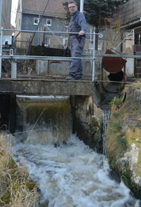 Der Müllermeister öffnet das Wehr. Der Wasserstand wird am Wehr reguliert.