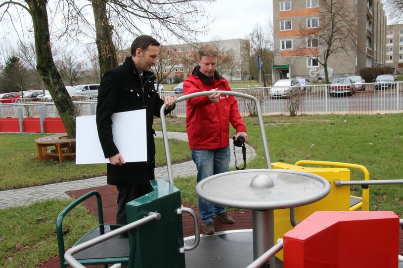 Roland Hauke erklärt Sven Walther von der Sparkasse, die das Rollstuhl-Karussell auf dem Integrationsspielplatz funktioniert. Für diesen wurden bei der letzten Aktion "Die Lausitz hilft!" mehr als 40.000 Euro gesammelt. Foto: jho