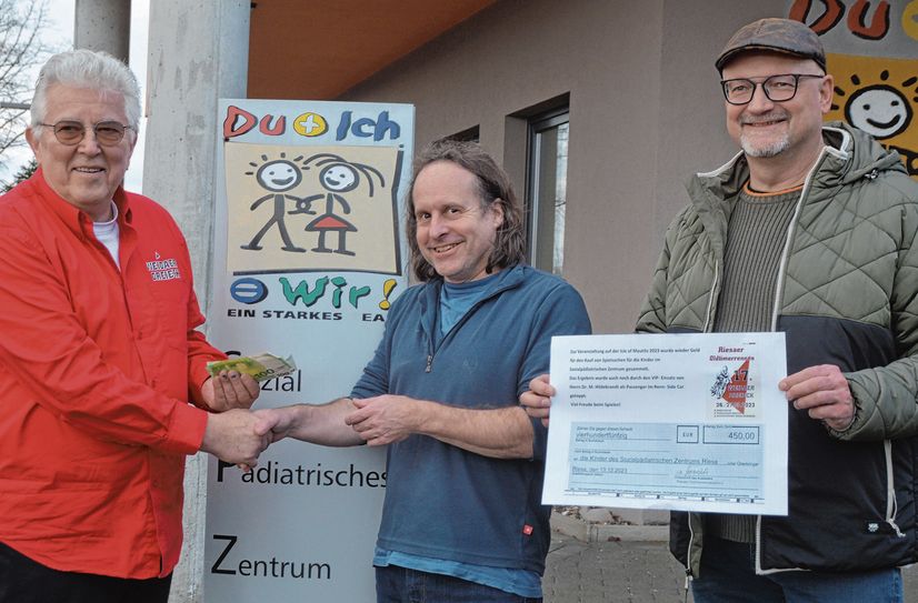 Spender und Spendenempfänger freuen sich gemeinsam: Hans-Jürgen Macioschek vom Riesaer Oldtimerrennsport e.V. (l.) und Holger Selle von Saxonia Catering (r.) übergeben 450 Euro an Dr. med. Martin Hildebrandt vom Sozialpädiatrischen Zentrum.