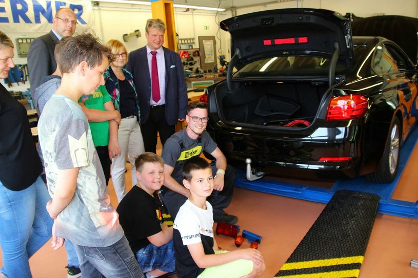 Kfz-Azubi Moritz Baumert erklärt den Oberschülern der Triebischtalschule und Gästen, wie aufwändig eine Anhängerkupplung montiert werden muss.       Foto: Farrar