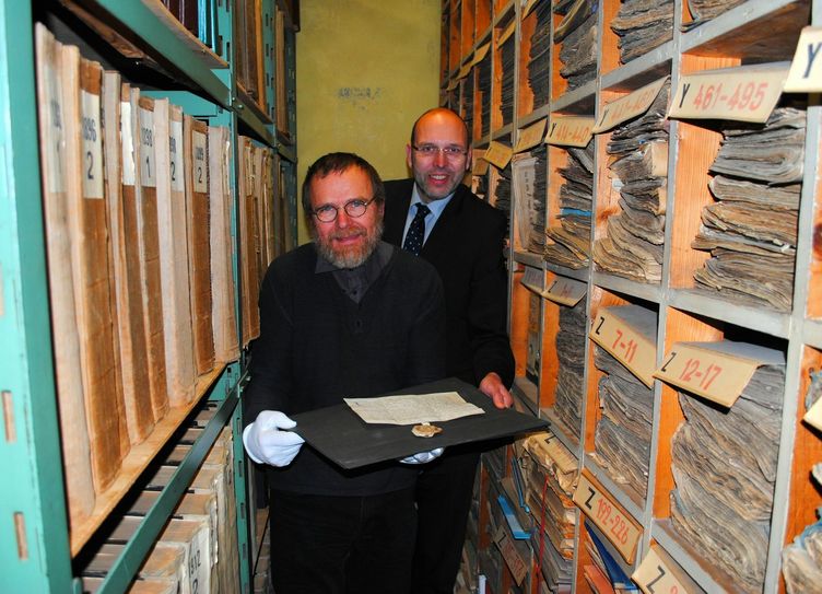 Stadtarchivar Tom Lauerwald und OB Olaf Raschke mit 700 Jahren Stadtgeschichte „im Griff“.