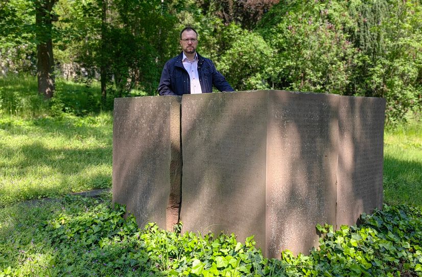 Holger Hase am Block-Grabstein für die Bombenopfer der Luftangriffe. Gepflegt ist das Umfeld nicht.