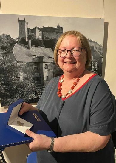 Christa Kämpfe hält die Ehrenwappen-Auszeichnung in den Händen.