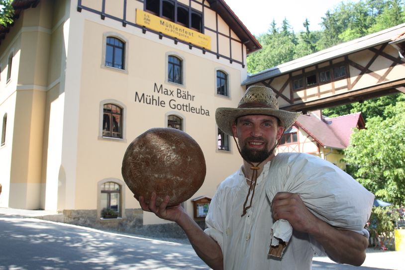 Bäcker Jan Punte (37) aus Bad Gottleuba mit frisch gebackenem Brot aus dem Holzbackofen. Die Max Bähr Mühle lädt zum 20. Mühlentag ein. Foto: D. Förster