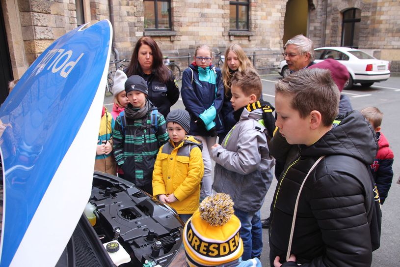 Die Polizei besitzt auch E-Autos. Hier schauen die Kids in den Motorraum eines Renault.