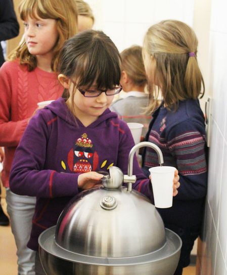Die Kinder der Fischmarkt-Grundschule nehmen den Trinkwasserbrunnen in Betrieb. Foto: SWG