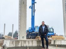 Schulleiter Florian Foltin vor einer der Stützen der neuen Dreifachhalle, die jetzt aufgebaut wird.