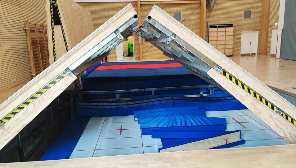 Der Sportboden klappt sich über dem Trampolin später hydraulisch auf.