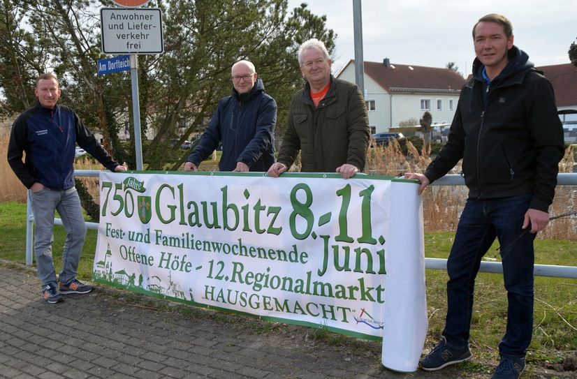 Das Banner zu 750 Jahre Glaubitz hängt. Martin Reichstädter von der Feuerwehr, Lutz Härtel vom Sportverein Einheit Glaubitz, Lutz Thiemig, Bürgermeister, und Martin Rettig vom Kulturverein (v.l.) freuen sich, dass das erste Banner hängt.
